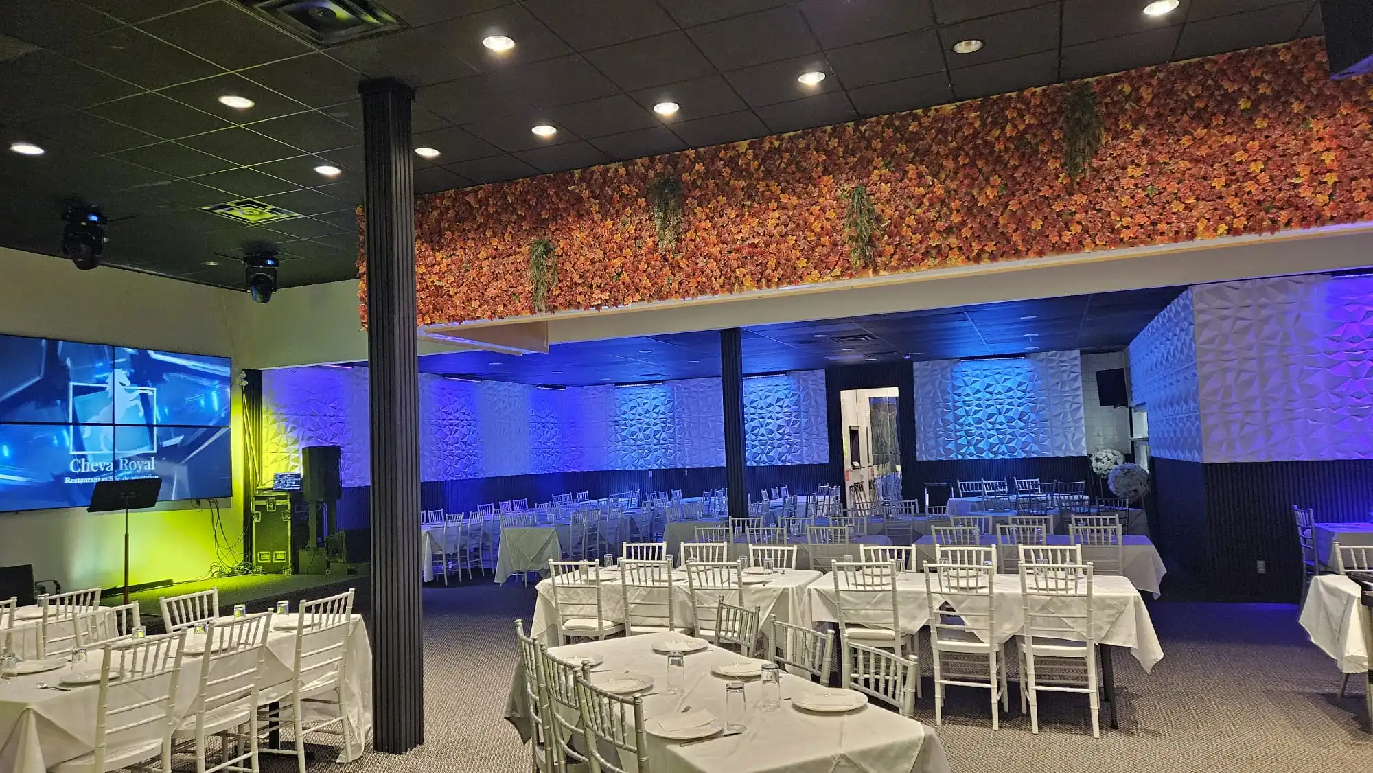 Elegant reception hall in Laval with banquet tables, white Chiavari chairs, stage lighting, and modern decor set for a wedding or corporate event